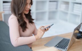 podnikání. Home lifestyle woman relaxing sleeping on sofa patio living room. Happy lady sitting on comfortable sofa using smartphone mobile while select listen music Tropical vacation